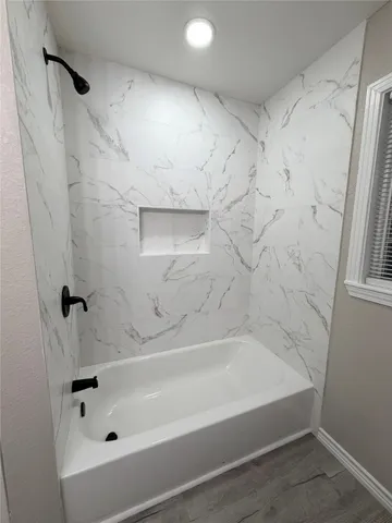 a bathroom with bathtub and shower