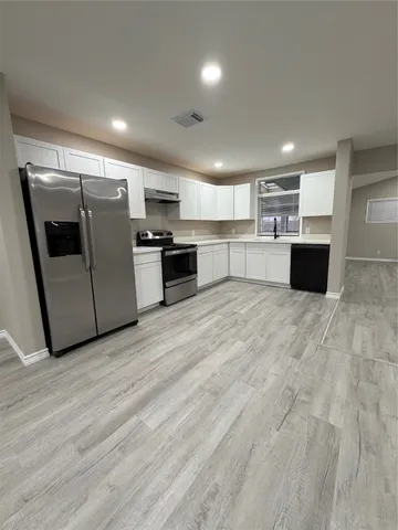 a kitchen with a refrigerator sink a microwave and cabinets