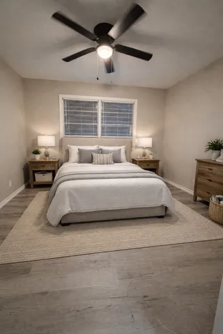 a bedroom with a bed ceiling fan and window