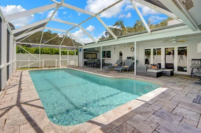 a view of a backyard with table and chairs under an umbrella
