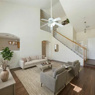 a living room with furniture flowerpot and wooden floor