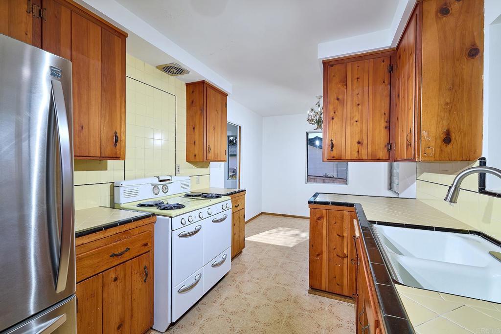 920 Stratford Drive Encinitas, CA 92024 - Photo 11 of 57 a kitchen with stainless steel appliances granite countertop a sink stove and refrigerator