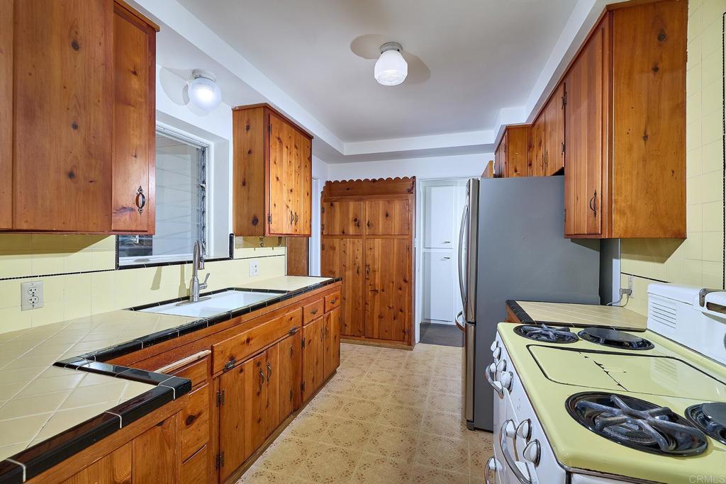 920 Stratford Drive Encinitas, CA 92024 - Photo 12 of 57 a kitchen with stainless steel appliances granite countertop a sink stove and refrigerator