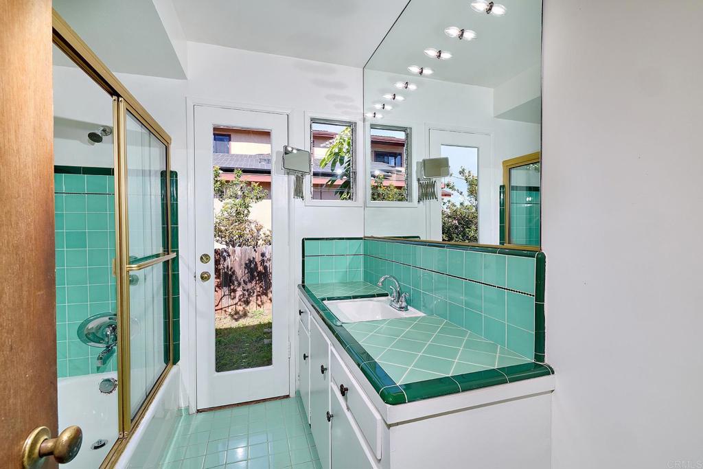 920 Stratford Drive Encinitas, CA 92024 - Photo 17 of 57 a bathroom with a sink a mirror and shower
