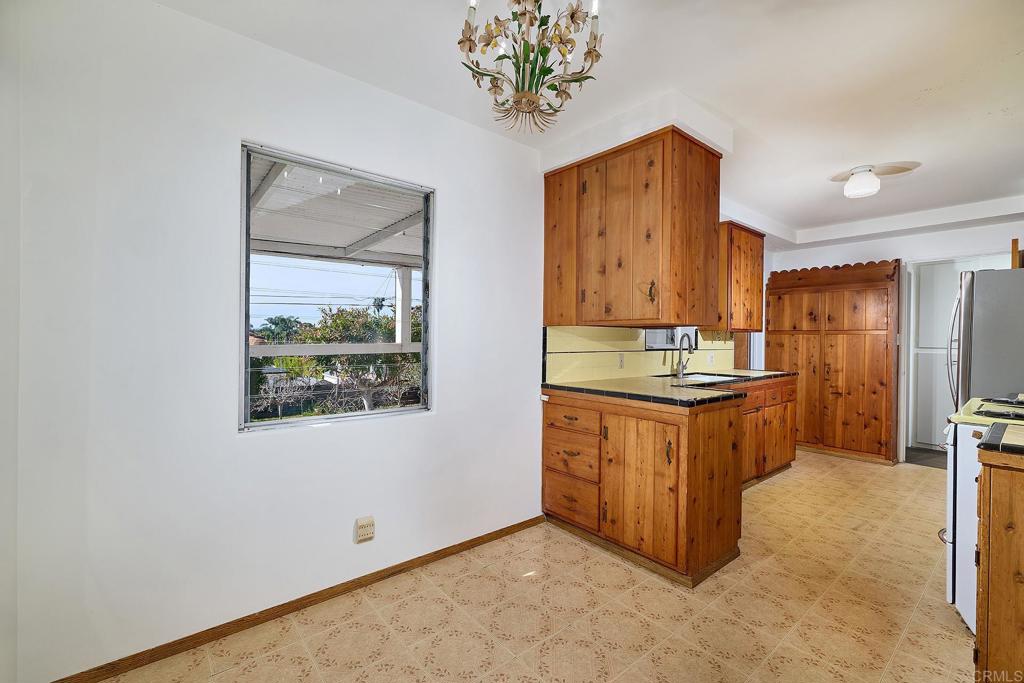 920 Stratford Drive Encinitas, CA 92024 - Photo 8 of 57 a kitchen with stainless steel appliances granite countertop a stove a refrigerator and a wooden cabinets