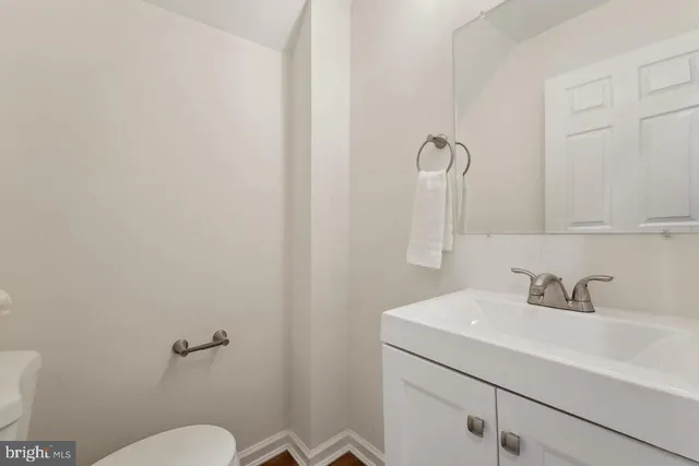 a bathroom with a sink mirror and toilet