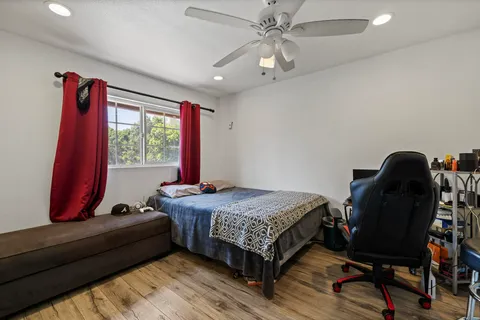 a view of an empty room with window and wooden floor