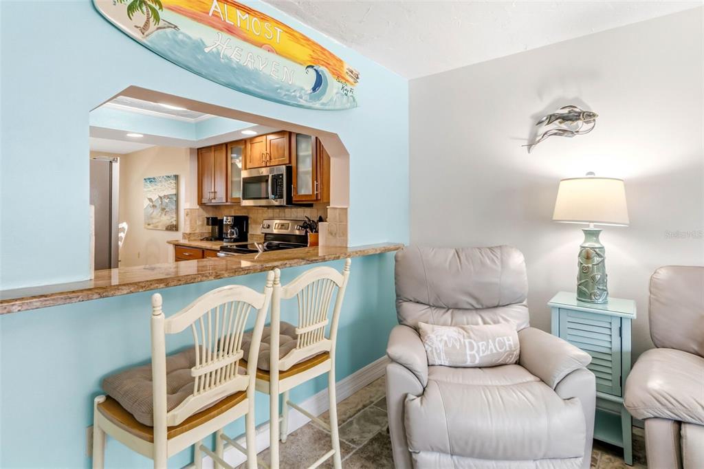 6500 Midnight Pass Road, Unit 208 Sarasota, FL 34242 - Photo 12 of 36 a living room with furniture a flat screen tv and a table