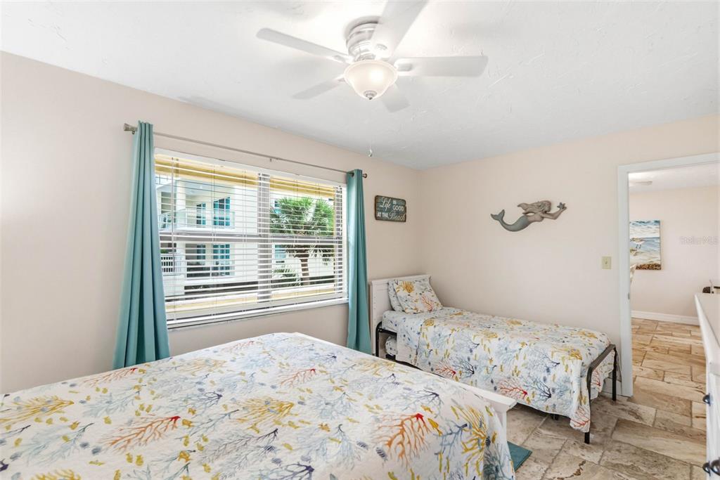6500 Midnight Pass Road, Unit 208 Sarasota, FL 34242 - Photo 20 of 36 a bedroom with a large bed and a chandelier