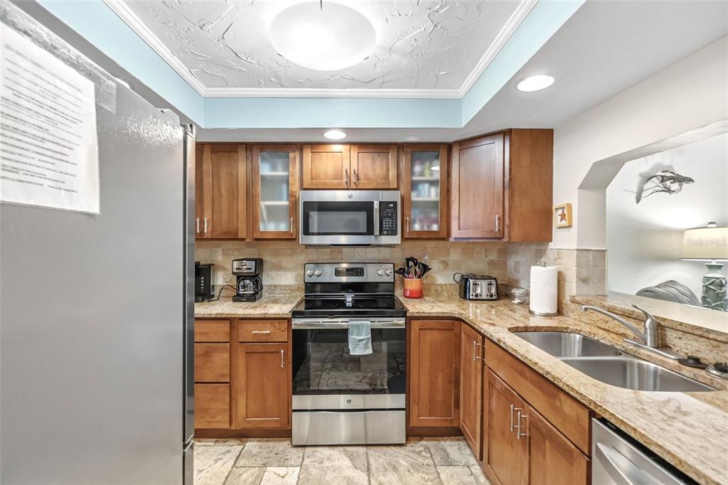 6500 Midnight Pass Road, Unit 208 Sarasota, FL 34242 - Photo 8 of 36 a kitchen with stainless steel appliances granite countertop a sink a stove a microwave a refrigerator cabinets and a window