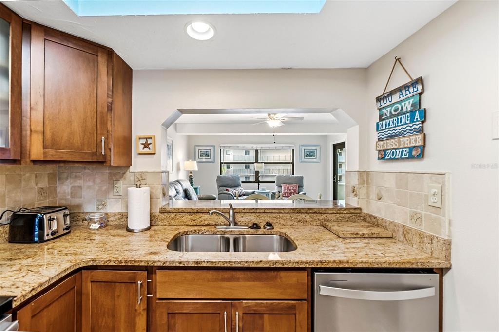 6500 Midnight Pass Road, Unit 208 Sarasota, FL 34242 - Photo 9 of 36 a kitchen with granite countertop a sink and a stove