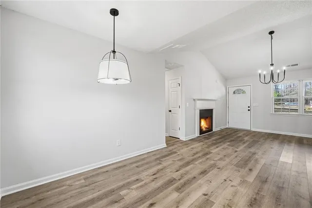 a view of a room with a fireplace wooden floor and white walls