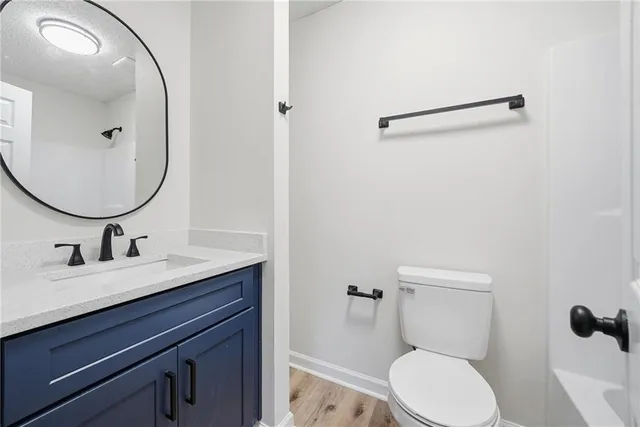 a bathroom with a toilet a sink and mirror