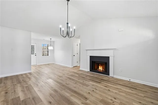a view of empty room with fireplace and wooden floor