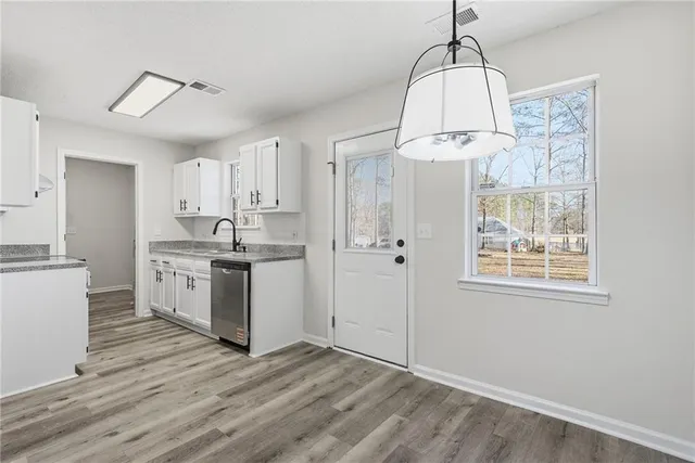 a kitchen with kitchen island white cabinets and wooden floor