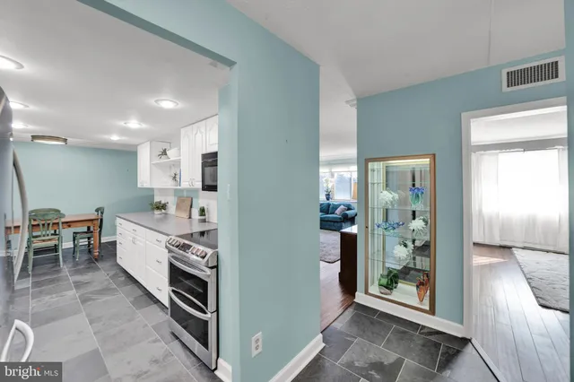 a large kitchen with stainless steel appliances granite countertop a refrigerator and a sink