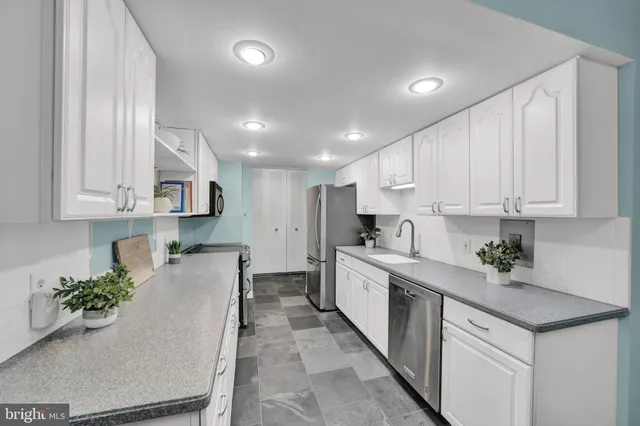 a kitchen with white cabinets sink and white appliances