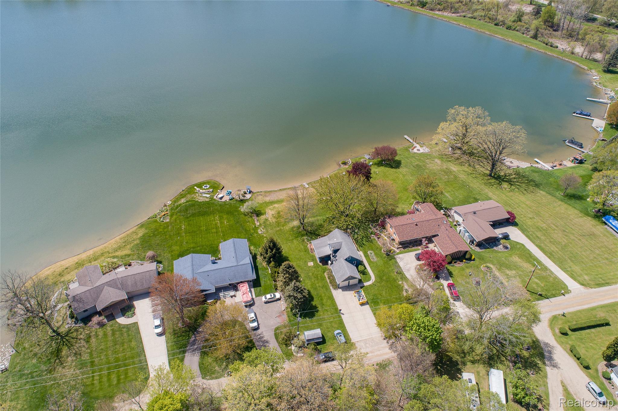 2855 Farmers Creek Road Metamora, MI 48455 - Photo 51 of 51 Spacious waterfront property featuring a private dock, expansive green lawn, mature trees, and direct lake access