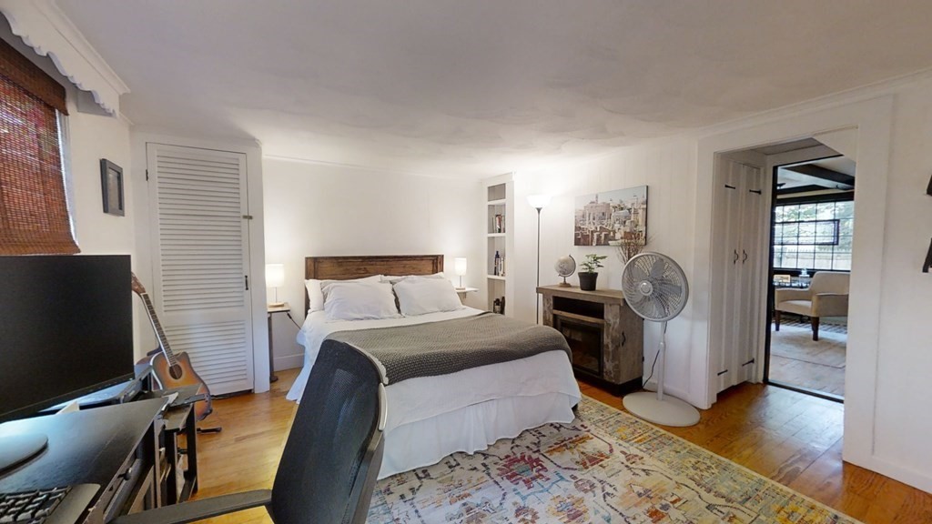 5 Pleasant Street Amesbury, MA 01913 - Photo 25 of 36 a bedroom with a bed and wooden floor