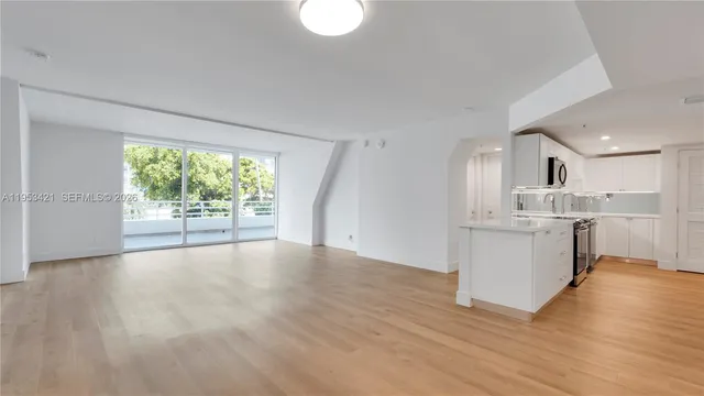 a view of large kitchen with wooden floor and windows