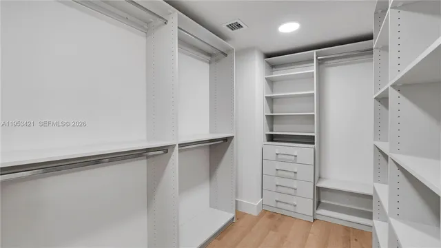 a view of walk in closet with empty racks