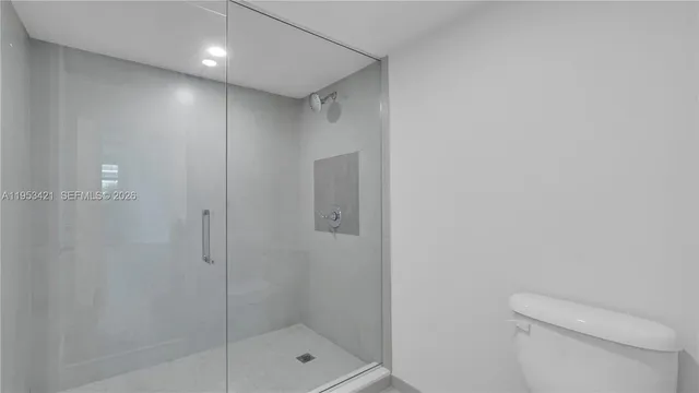 a bathroom with a shower a toilet and sink