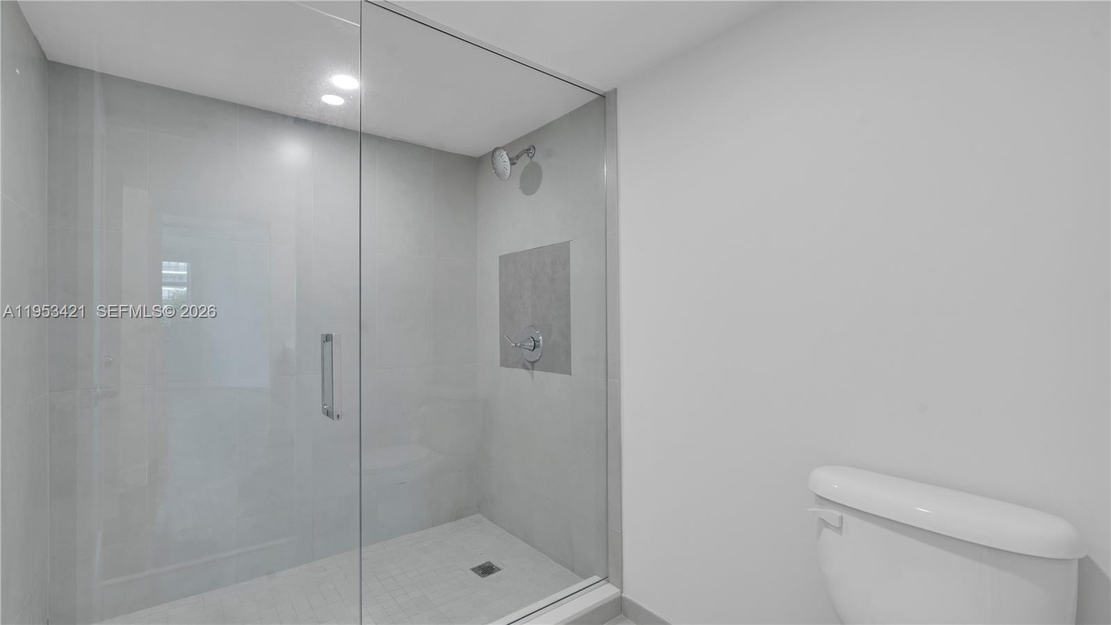 555 Northeast 34th Street, Unit 705 Miami, FL 33137 - Photo 14 of 28 a bathroom with a shower a toilet and sink