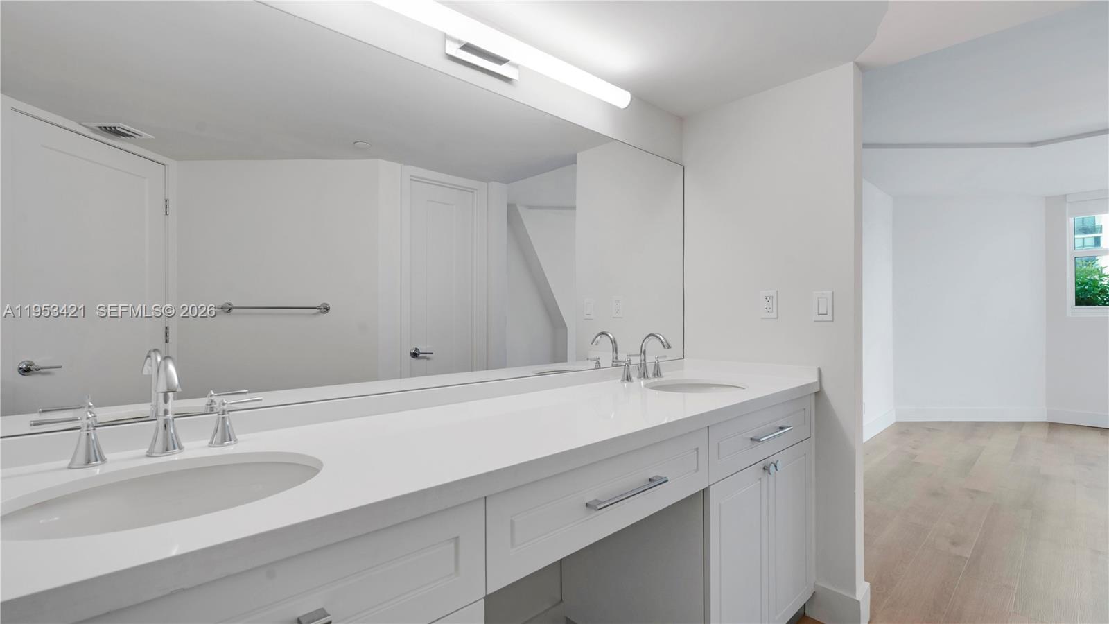 555 Northeast 34th Street, Unit 705 Miami, FL 33137 - Photo 15 of 28 a bathroom with a sink and a mirror