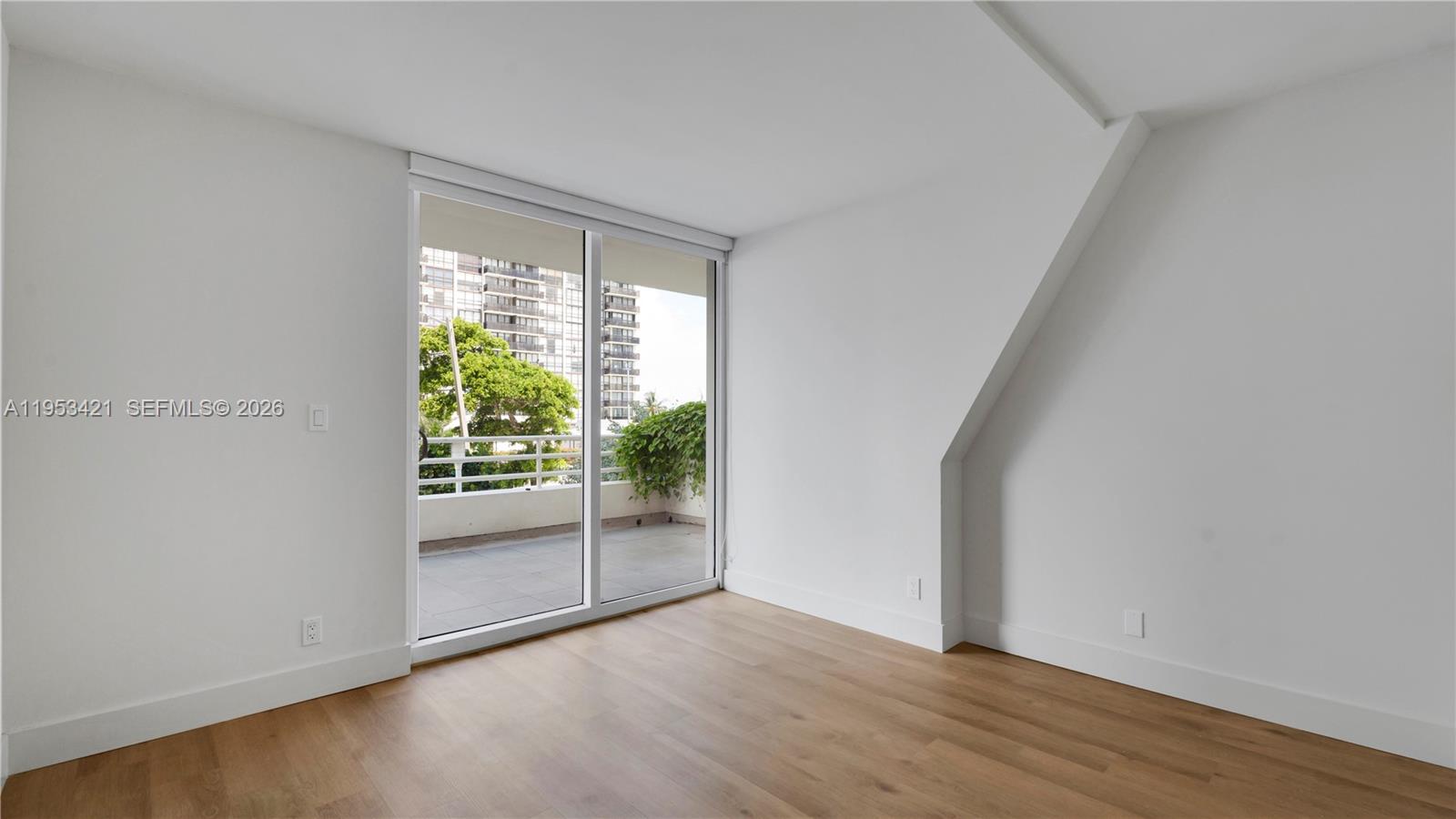 555 Northeast 34th Street, Unit 705 Miami, FL 33137 - Photo 16 of 28 an empty room with wooden floor and windows