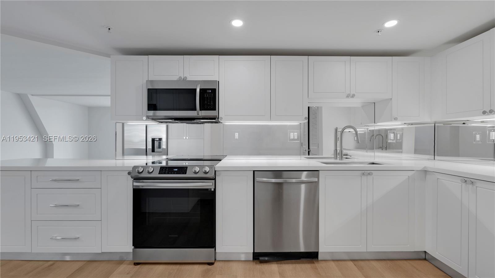 555 Northeast 34th Street, Unit 705 Miami, FL 33137 - Photo 4 of 28 a kitchen with appliances a sink and cabinets