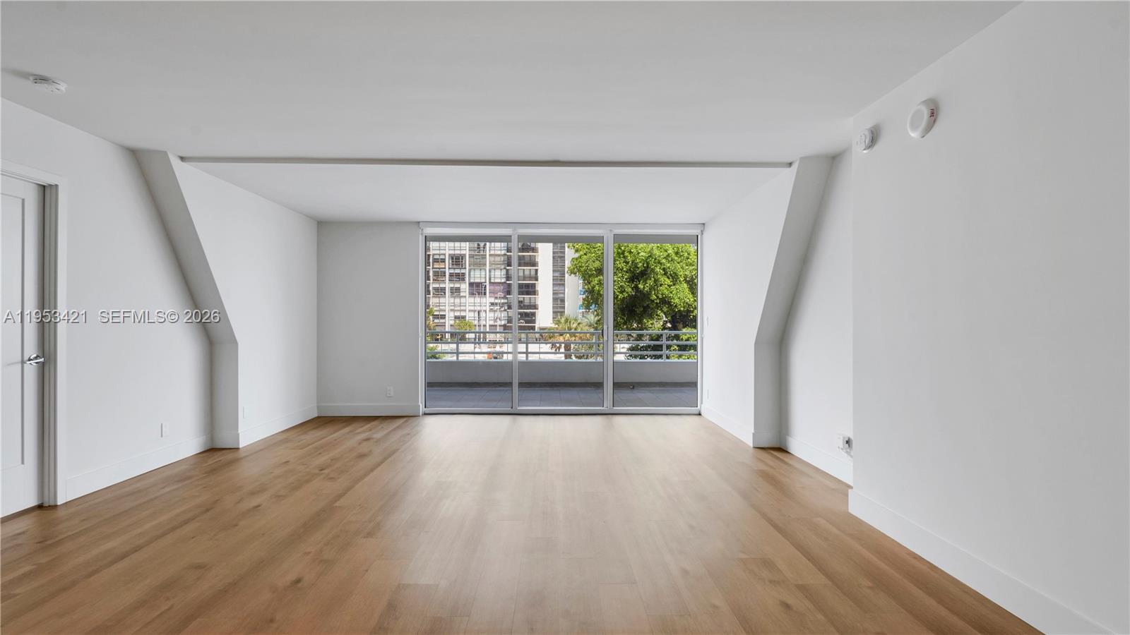 555 Northeast 34th Street, Unit 705 Miami, FL 33137 - Photo 5 of 28 a view of an empty room with a window and wooden floor