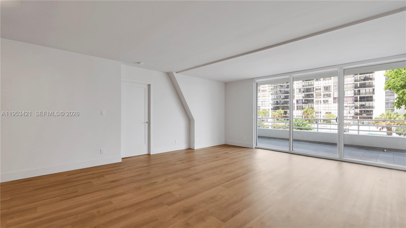 555 Northeast 34th Street, Unit 705 Miami, FL 33137 - Photo 6 of 28 a view of an empty room with wooden floor and a window