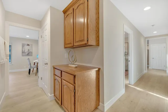 a kitchen with a stove top oven a sink dishwasher a dining table and chairs with wooden floor