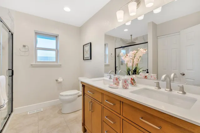 a view of an empty room with cabinet and mirrors