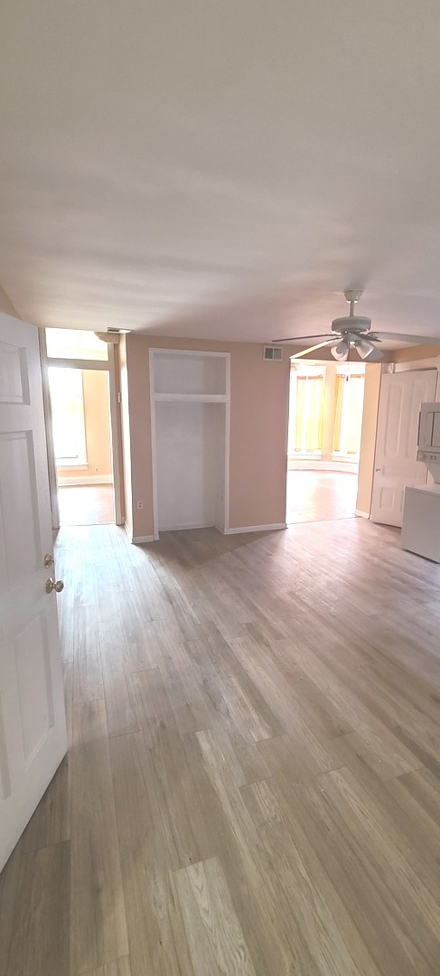 1332 West 18th Street, Unit 2F Chicago, IL 60608 - Photo 4 of 11 wooden floor in an empty room with a window