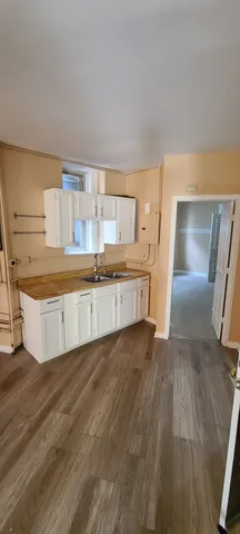 a view of a kitchen with a sink stove cabinets and a window