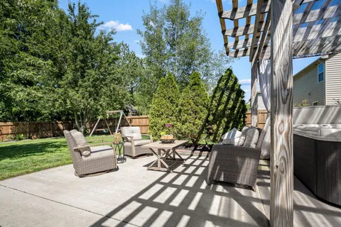 a view of a patio with table and chairs potted plants and floor to ceiling window and wooden fence