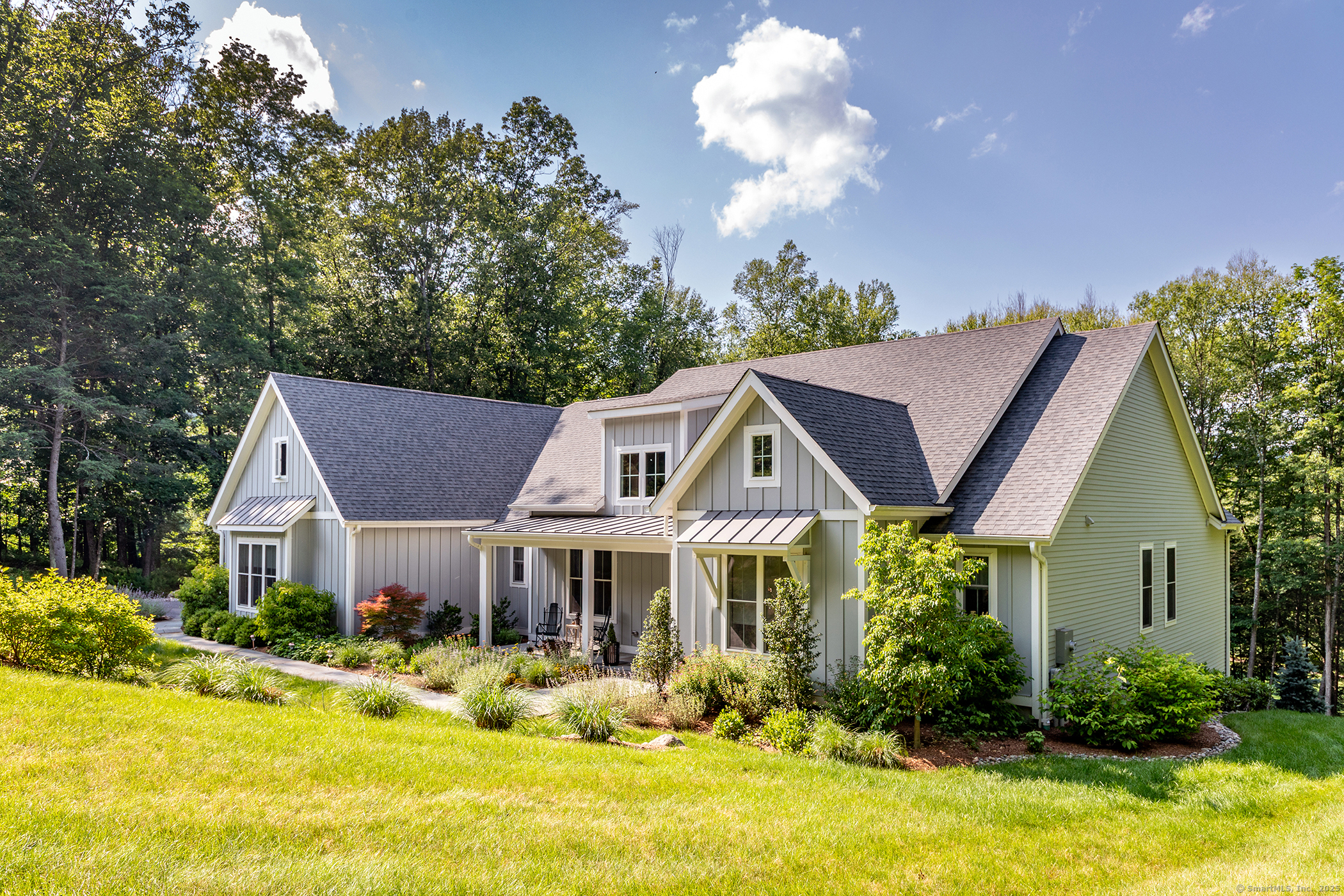 73 Long River Road Sherman, CT 06784 - Photo 2 of 31 a front view of house with yard outdoor seating and covered with trees