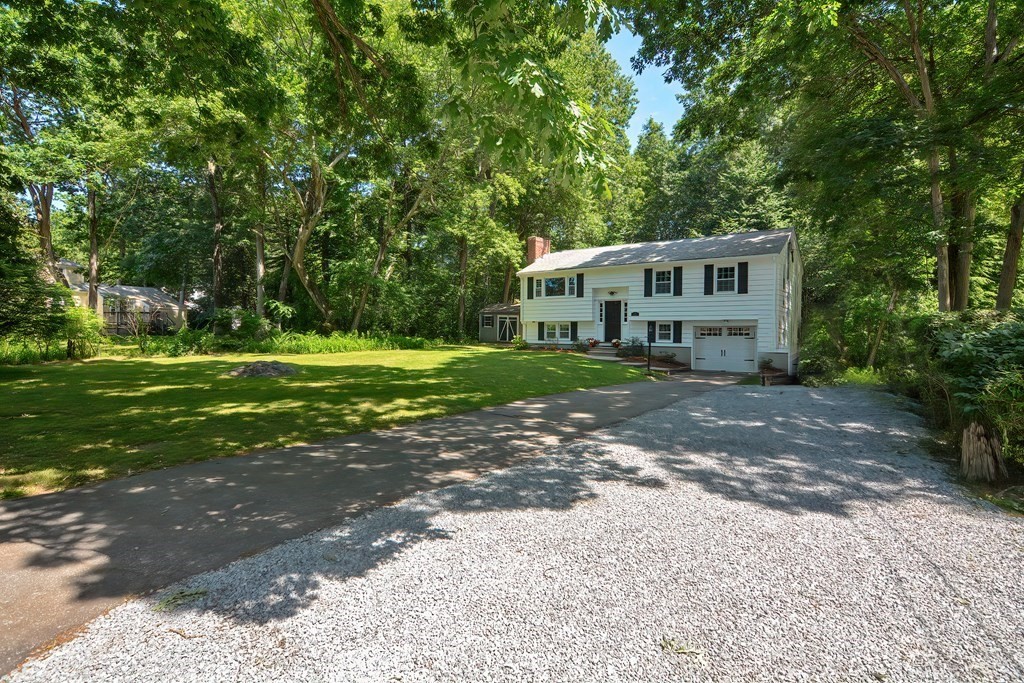 a front view of a house with a yard and trees