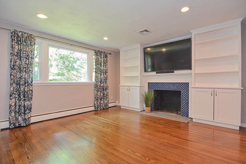 2 Labo Lane Bedford, MA 01730 - Photo 16 of 40 an empty room with windows fireplace and wooden floor