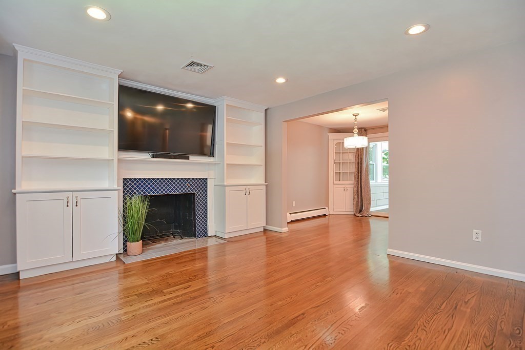 2 Labo Lane Bedford, MA 01730 - Photo 17 of 40 a view of an empty room with wooden floor fireplace and a window
