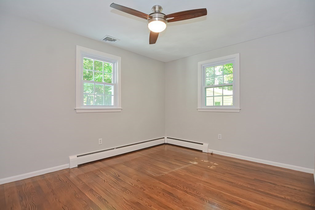 2 Labo Lane Bedford, MA 01730 - Photo 19 of 40 an empty room with wooden floor ceiling fan and windows