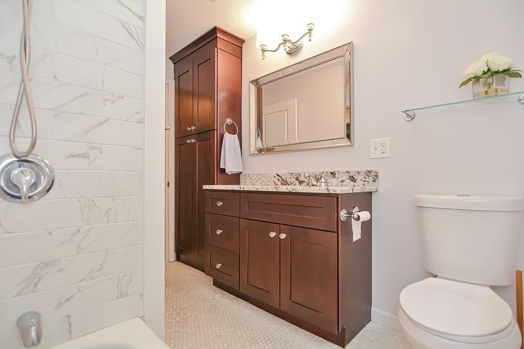 2 Labo Lane Bedford, MA 01730 - Photo 21 of 40 a bathroom with a granite countertop toilet sink and mirror
