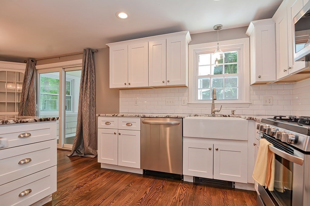 2 Labo Lane Bedford, MA 01730 - Photo 6 of 40 a kitchen with granite countertop white cabinets and white appliances with wooden floor