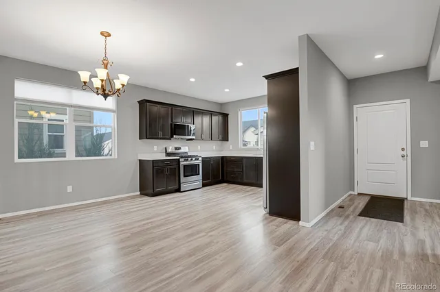 a kitchen with stainless steel appliances a stove top oven a sink dishwasher a refrigerator and a microwave