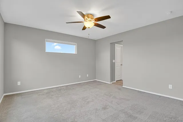 an empty room with closet and ceiling fan