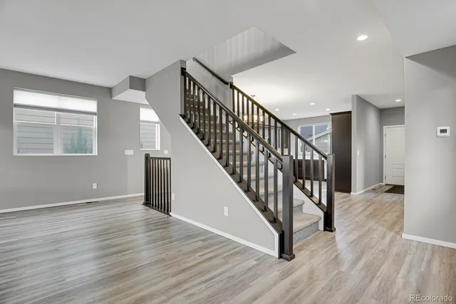 a view of a hallway with wooden floor and stairs