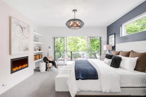 a bedroom with a bed a fireplace and a large window