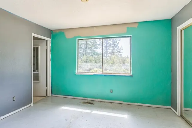 an empty room with closet and windows