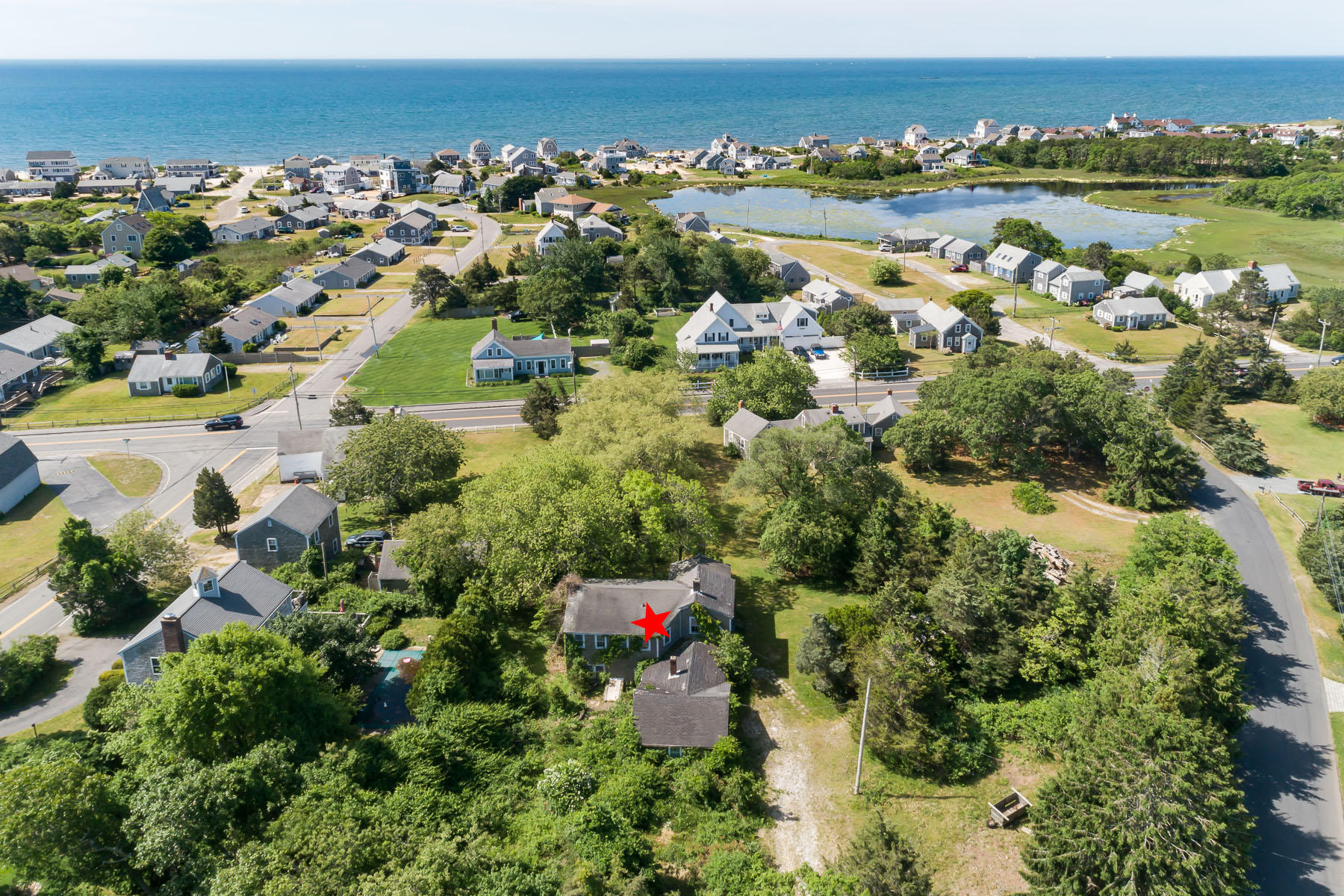 an aerial view of residential houses with outdoor space and trees